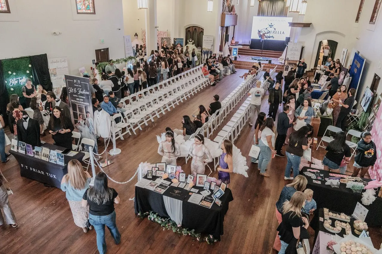 Guests exploring vendor booths around a runway and presentation stage at a previous SD Royalty Events expo